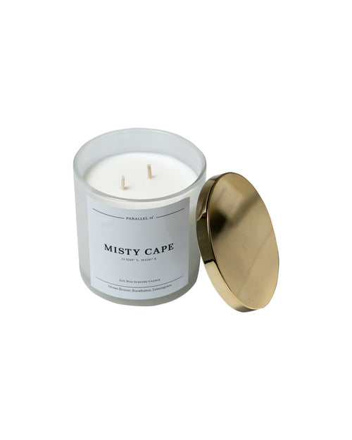 Candle in a white container with a gold lid on a white background